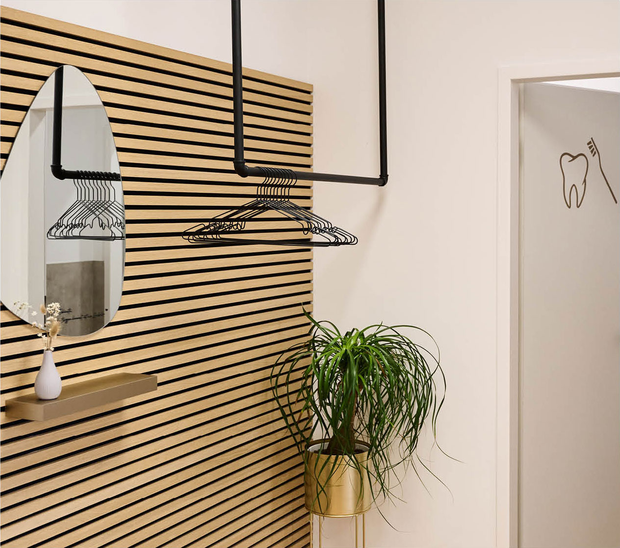 Im Wartebereich der Zahnarztpraxis Zahnlieblinge hat Zahnärztin Dr. Reuschl in Kombination mit hellem Holz und Pflanzen eine Garderobe im Scandi Stil eingerichtet.